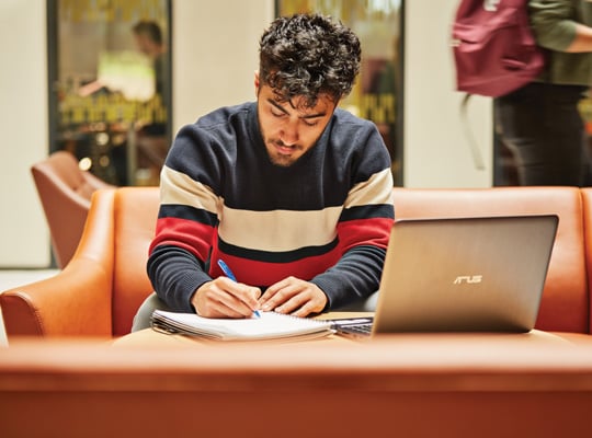 student at table with notebook